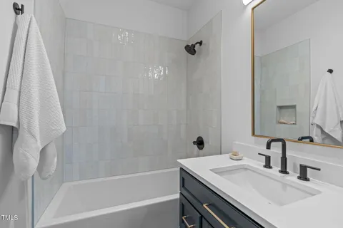 a bathroom with a sink vanity tub and a mirror