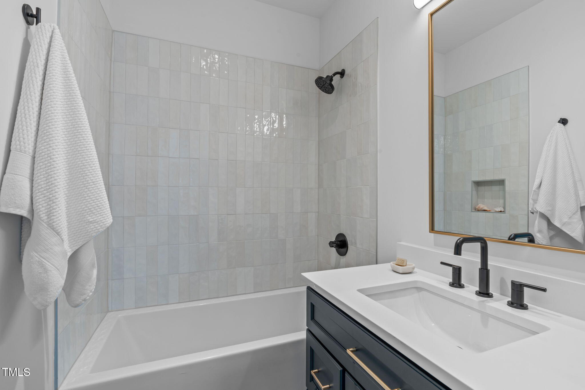 1105 Glascock Street, Unit 101 Raleigh, NC 27610 - Photo 20 of 39 a bathroom with a sink vanity tub and a mirror