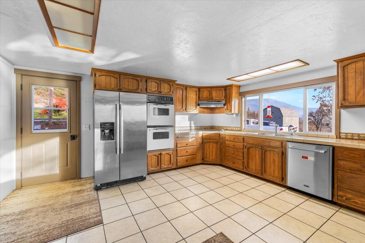 1360 Oxyoke Road Grants Pass, OR 97526 - Photo 11 of 39 a kitchen with stainless steel appliances a refrigerator sink and cabinets