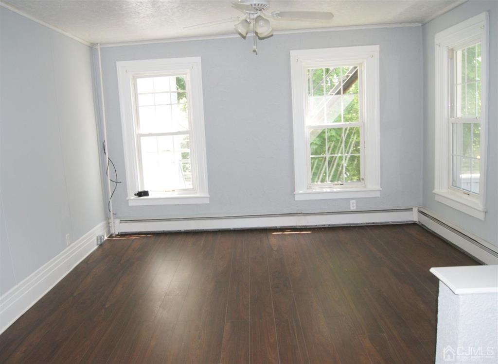 203 Woodbridge Avenue, Unit 2 Metuchen, NJ 08840 - Photo 4 of 13 an empty room with wooden floor and windows