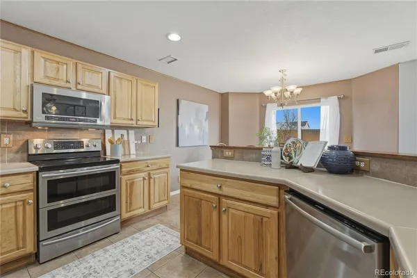 a kitchen with stainless steel appliances granite countertop a sink stove and microwave
