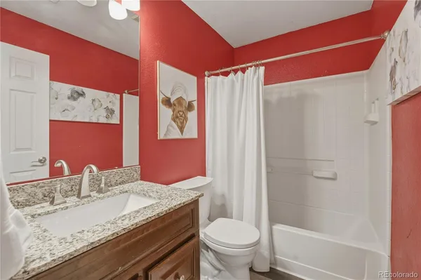 a bathroom with a granite countertop sink toilet and shower