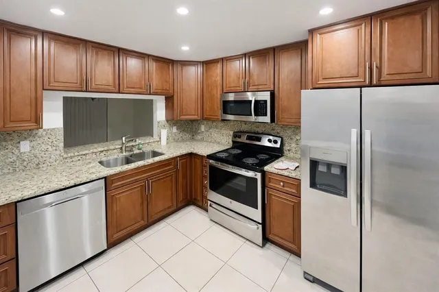 a kitchen with granite countertop stainless steel appliances and cabinets