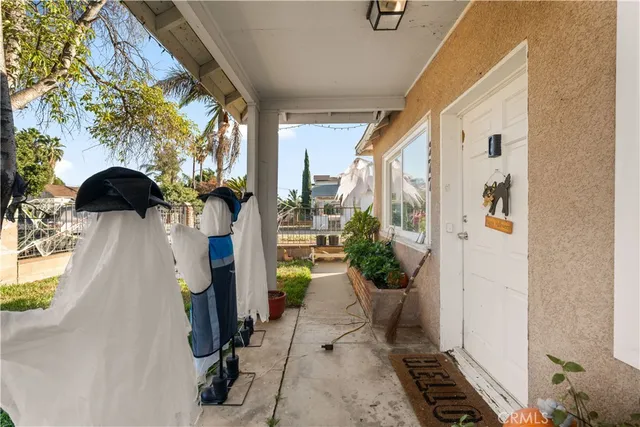 a view of a patio with table and chairs potted plants and large tree