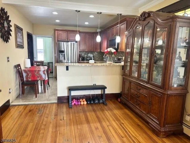 a kitchen with a refrigerator a stove a sink dishwasher with wooden cabinets and dining table