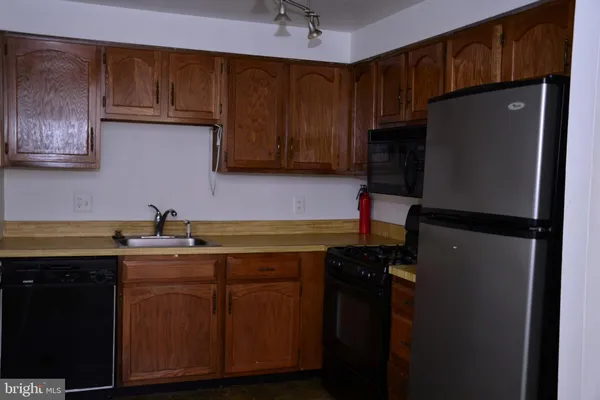 a kitchen with a sink a refrigerator and cabinets