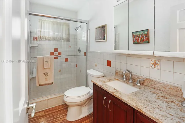 a bathroom with a granite countertop sink a toilet and shower