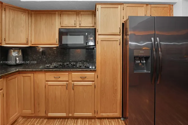 a kitchen with stainless steel appliances granite countertop a refrigerator and a stove