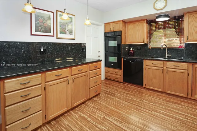 a kitchen with granite countertop wooden floors granite counter tops and a window