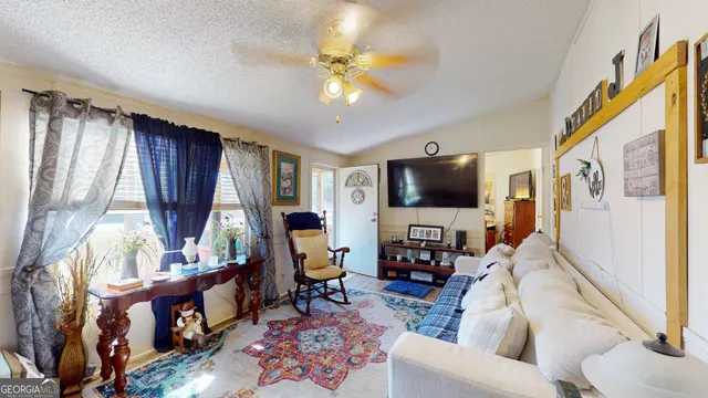 a living room with furniture a flat screen tv and a window