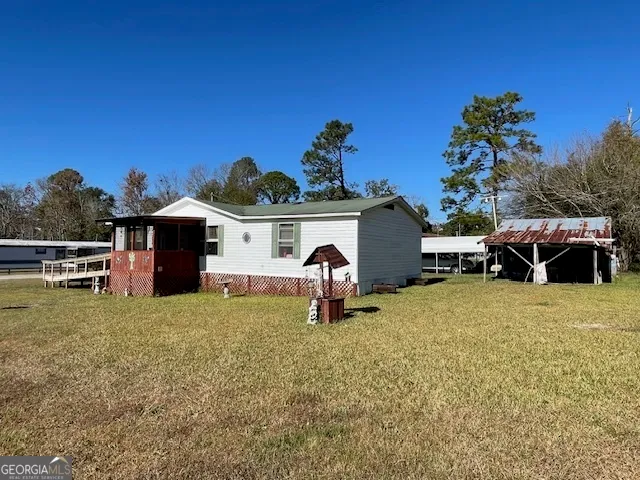 a view of a house with a wooden deck and a yard