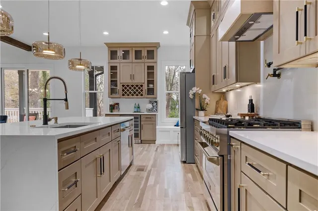 a kitchen with stainless steel appliances a sink stove and cabinets