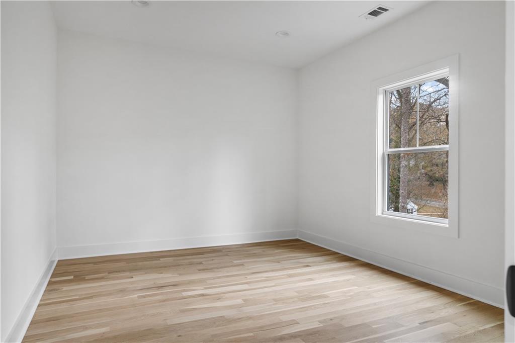 515 Chevelle Lane Decatur, GA 30030 - Photo 23 of 39 an empty room with wooden floor and windows
