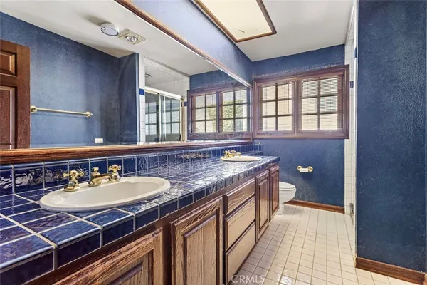 a spacious bathroom with a granite countertop sink and a mirror