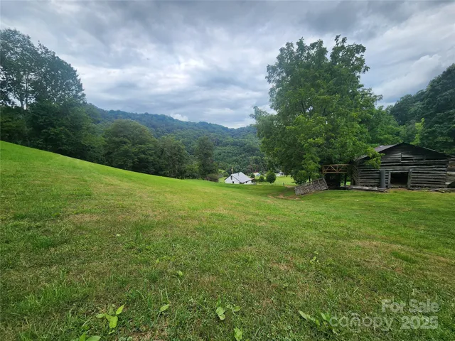 a view of a green field with wooden fence