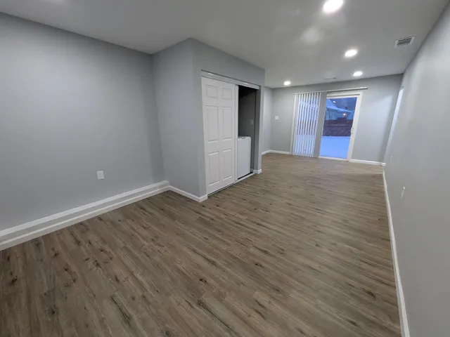 a kitchen with granite countertop a stove top oven a sink dishwasher and a refrigerator with wooden floor