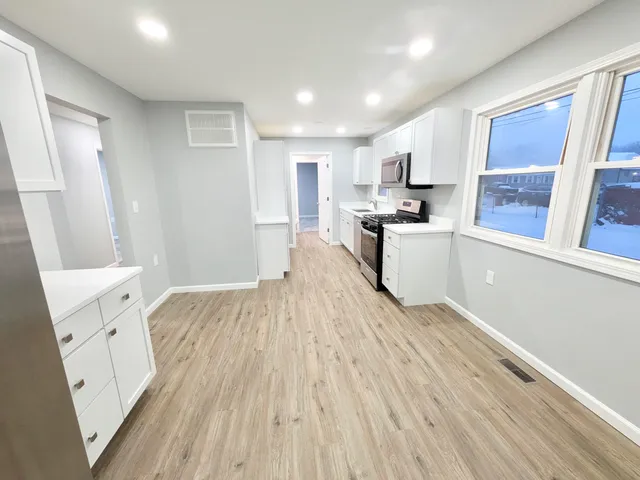 a large kitchen with a wooden floor and cabinets