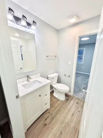 a bathroom with a sink and mirror with toilet