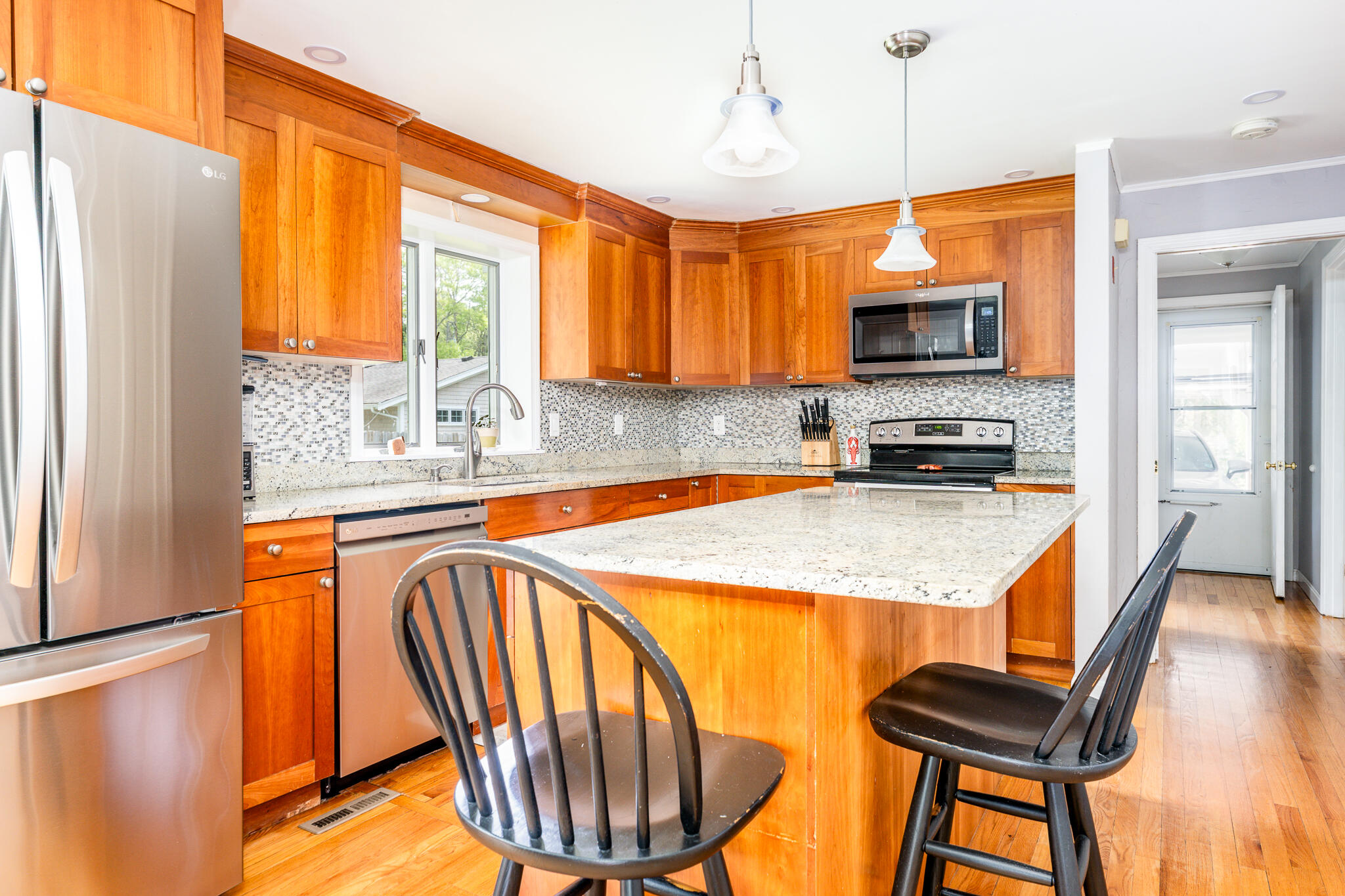 61 Angus Way Centerville, MA 02632 - Photo 12 of 59 a kitchen with stainless steel appliances granite countertop a refrigerator a stove a sink a dining table and chairs with wooden floor