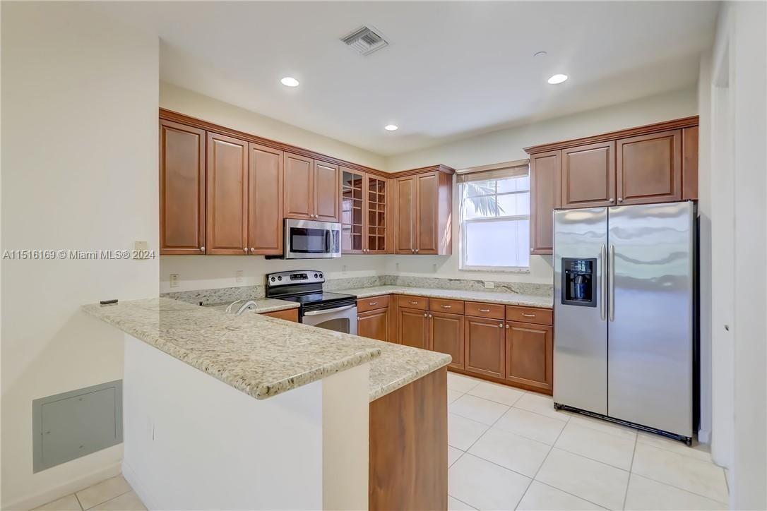 a kitchen with stainless steel appliances granite countertop a refrigerator a sink dishwasher and a stove