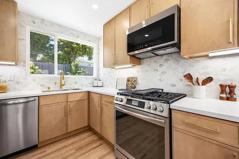 a kitchen with stainless steel appliances a sink a stove and microwave