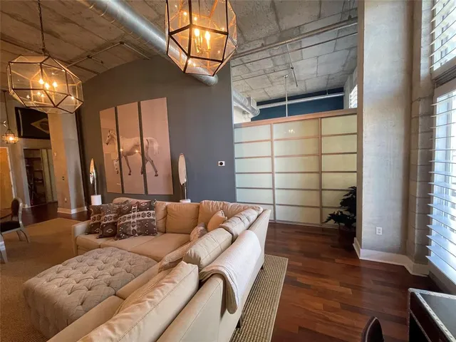 a living room with furniture a chandelier and a flat screen tv