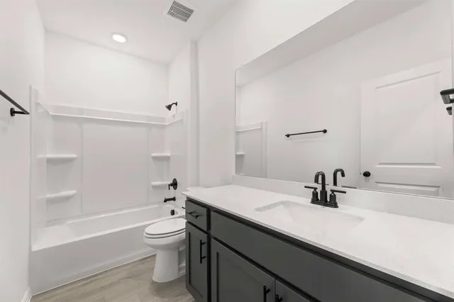 a bathroom with a sink a toilet and a large mirror