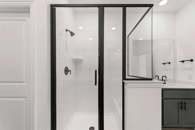 a bathroom with a shower sink and mirror