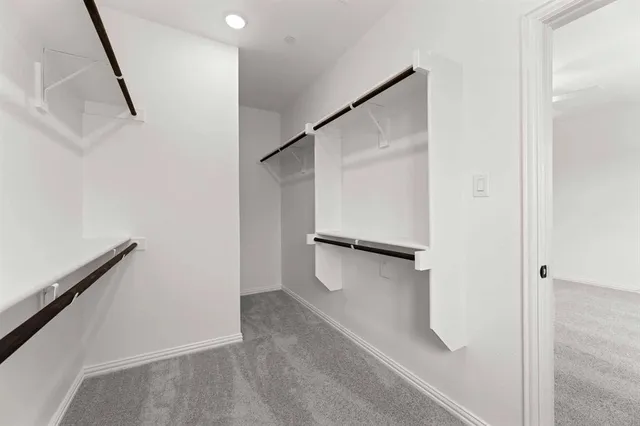 a view of walk in closet with empty racks