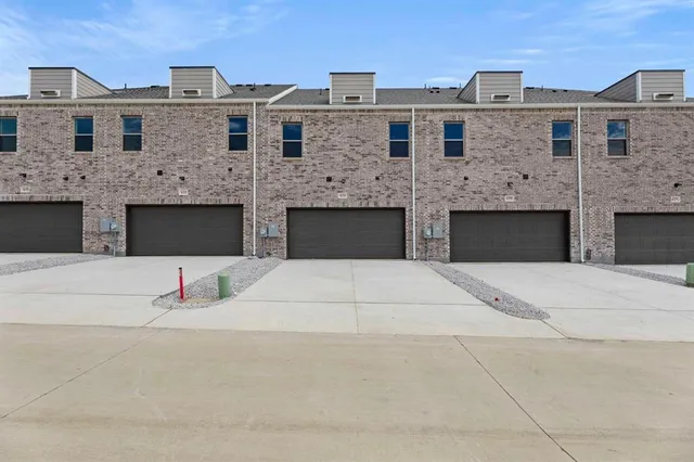 a front view of a building with parking space and garage