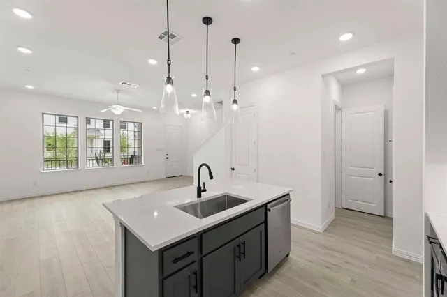 a kitchen with a sink center island with wooden floor