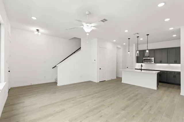 a large white kitchen with a large window stainless steel appliances