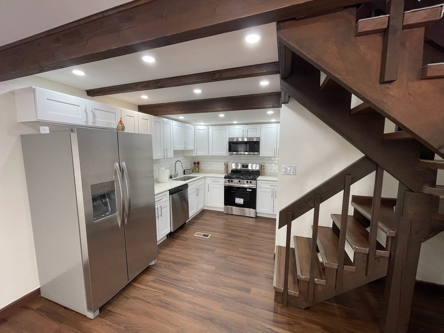 149 Forest Avenue, Unit D Fox Lake, IL 60020 - Photo 25 of 44 a kitchen with wooden floors and stainless steel appliances