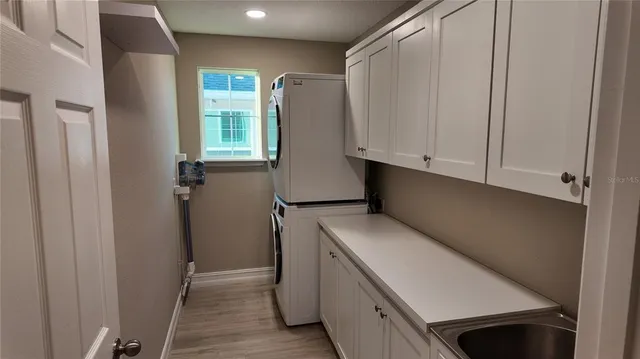 an empty room with wooden floor chandelier and window