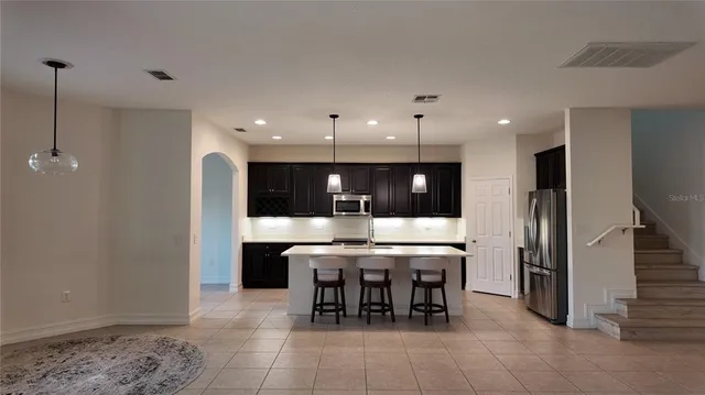 a large kitchen with a table and chairs