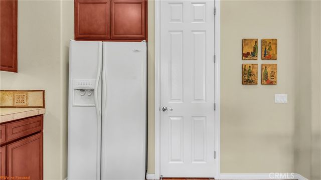 a kitchen with a sink dishwasher and a refrigerator with wooden floor