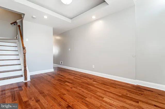 a view of room with wooden floor and stairs