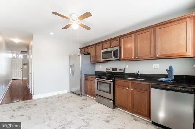 a kitchen with stainless steel appliances granite countertop a stove sink and cabinets