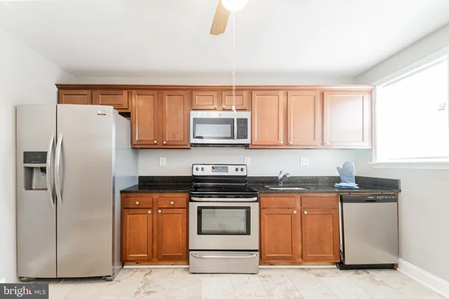 a kitchen with granite countertop white cabinets and stainless steel appliances