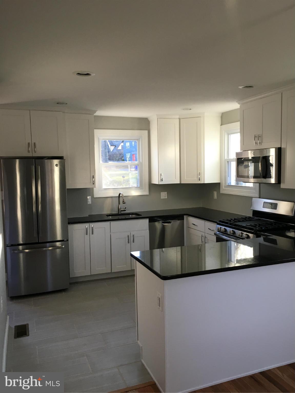 620 Woodside Parkway Silver Spring, MD 20910 - Photo 2 of 11 a kitchen with granite countertop a refrigerator and a sink