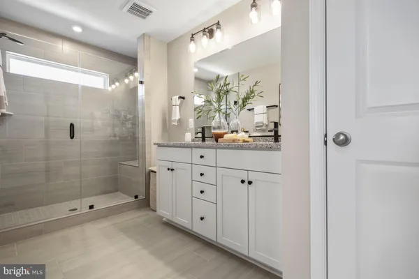 a bathroom with a double vanity sink toilet and shower