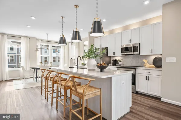 a kitchen with stainless steel appliances kitchen island granite countertop a stove a sink a dining table and chairs