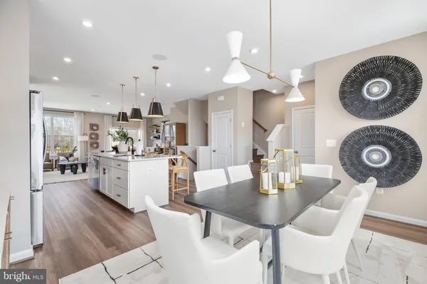 a kitchen with a dining table chairs and white cabinets