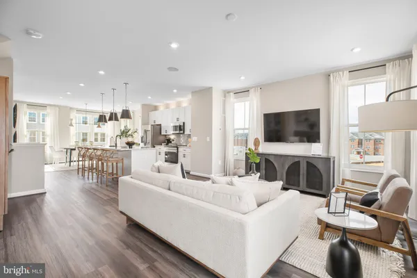 a living room with furniture a flat screen tv and kitchen view