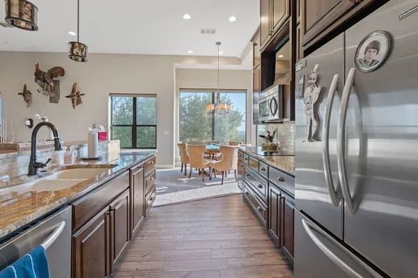 a room with pool table a flat screen tv and kitchen view