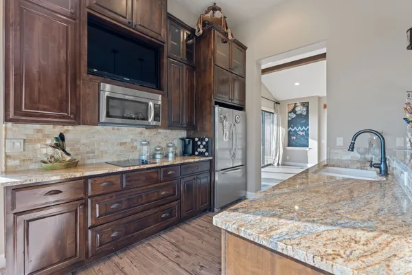 a dining hall with stainless steel appliances kitchen island granite countertop a table and chairs in it