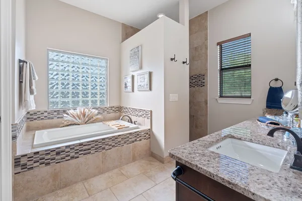 a bathroom with a granite countertop sink a toilet and a large mirror