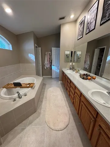 a en suite bathroom with a double vanity sink and a mirror