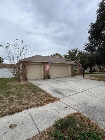 a view of a house with a yard and large tree