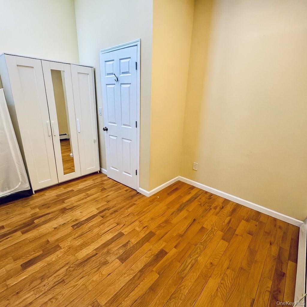 1243 Pea Pond Road North Bellmore, NY 11710 - Photo 11 of 16 a view of empty room with wooden floor and cabinet